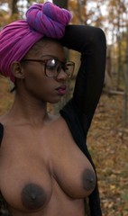 Tall ebony model with big nipples posing naked in the forest.